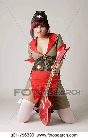 Stock Photo - Rocker girl dressed as a nurse with a guitar. Fotosearch