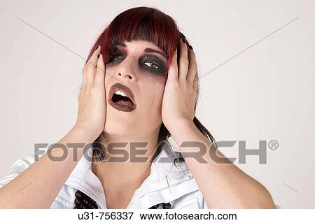 Stock Photo - Rocker girl with heavy makeup and tear running down looking desperate and depressed. Fotosearch