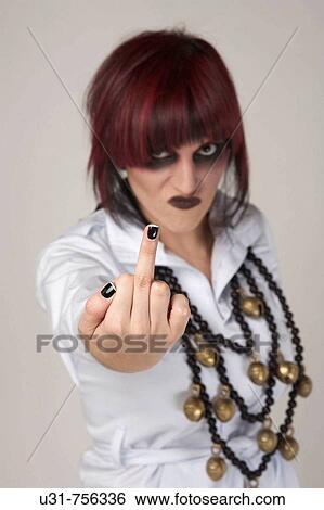 Stock Photograph - Rocker girl with heavy makeup showing the finger at the camera looking angry. Fotosearch
