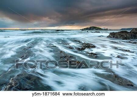 Rocky shores of Bantham at Dusk view towards Burgh Island, Devon, England, UK, Europe View Large Photo Image Picture - Rocky shores of Bantham at Dusk view towards Burgh Island, Devon, England, UK, Europe. Fotosearch