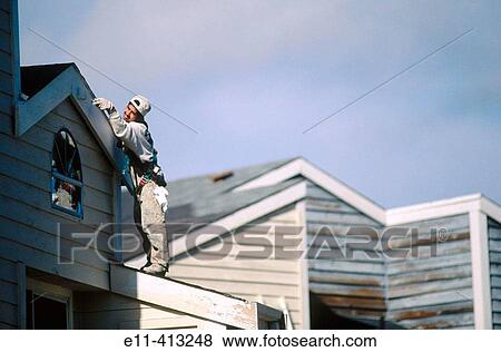 Stock Photo - Rolling paint onto facia building exterior. Fotosearch