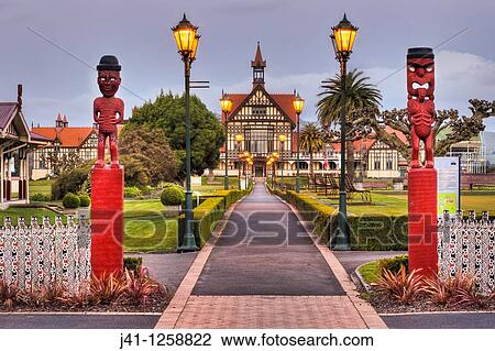 Rotorua Museum entrance pathway lined by lamps and Maori wooden carved figures, dusk, Government gardens, Rotorua. View Large Photo Image Stock Image - Rotorua Museum entrance pathway lined by lamps and Maori wooden carved figures, dusk, Government gardens, Rotorua.. Fotosearch