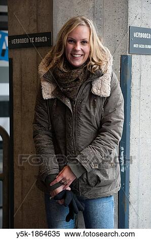 Rotterdam, Netherlands. Attractive, blonde woman in winter fashion, leaning against concrete pillar of an industrial building. View Large Photo Image Stock Photography - Rotterdam, Netherlands. Attractive, blonde woman in winter fashion, leaning against concrete pillar of an industrial building.. Fotosearch