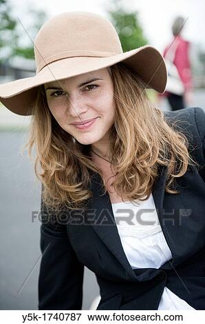 Rotterdam, Netherlands Portrait of a young, attractive brunette with hat and long, strait hair View Large Photo Image Stock Photo - Rotterdam, Netherlands Portrait of a young, attractive brunette with hat and long, strait hair. Fotosearch