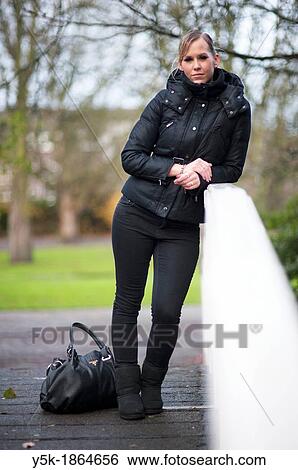 Rotterdam, Netherlands. Young, attractive blonde, in winter fashion, leaning against a railing or bridge railing. View Large Photo Image Stock Photograph - Rotterdam, Netherlands. Young, attractive blonde, in winter fashion, leaning against a railing or bridge railing.. Fotosearch
