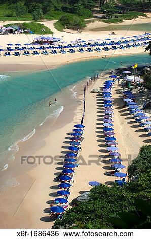 Rows of parasols on a sandy beach with crystal clear turquoise water along Naiharn Beach at at the southern tip of Phuket Island, Thailand View Large Photo Image Stock Photograph - Rows of parasols on a sandy beach with crystal clear turquoise water along Naiharn Beach at at the southern tip of Phuket Island, Thailand. Fotosearch