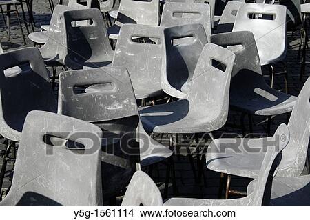 rows of stacked and jumbled gray plastic chairs View Large Photo Image Picture - rows of stacked and jumbled gray plastic chairs. Fotosearch