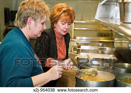 Royal Oak, Michigan - Members of St Dennis Catholic Church prepared and served a turkey Thanksgiving dinner to homeless and underprivileged persons in their community Brenda Simkins left and Charlene Gasiorowski cook part of the meal Copyright? Jim We View Large Photo Image Stock Photo - Royal Oak, Michigan - Members of St Dennis Catholic Church prepared and served a turkey Thanksgiving dinner to homeless and underprivileged persons in their community Brenda Simkins left and Charlene Gasiorowski cook part of the meal Copyright? Jim We. Fotosearch