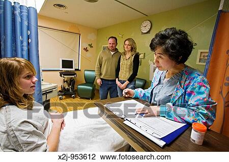 Stock Image - Royal Oak, Michigan - Registered nurse Sang Lee prepares 15-year-old Chelsea Errante for surgery in the Ghesquiere Family Center for Children's Surgery at William Beaumont Hospital Chelsea's parents, Elaine and John Errante, watch. Fotosearch