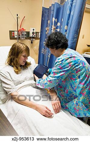 Royal Oak, Michigan - Registered nurse Sang Lee checks 15-year-old Chelsea Errante's blood pressure and she prepares Chelsea for surgery in the Ghesquiere Family Center for Children's Surgery at William Beaumont Hospital View Large Photo Image Stock Image - Royal Oak, Michigan - Registered nurse Sang Lee checks 15-year-old Chelsea Errante's blood pressure and she prepares Chelsea for surgery in the Ghesquiere Family Center for Children's Surgery at William Beaumont Hospital. Fotosearch