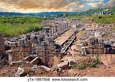 Stock Photo - Ruins of the Roman Columned street which was lined with shops & stores Down the centre of the street runs a canal which was full of running water from the Fountain of the Acropolis in the foreground Perge Perga archaeological site, Turkey. Fotosearch