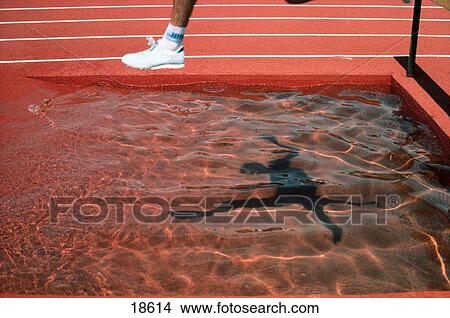 Picture - Runner leaping over obstacle. Fotosearch
