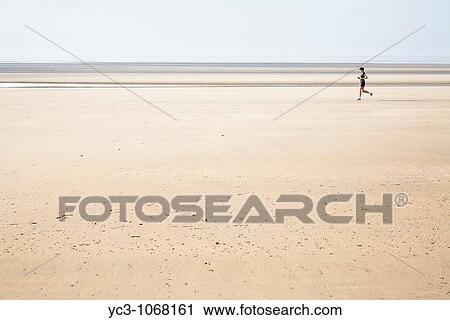 Stock Image - Running on the beach. Fotosearch