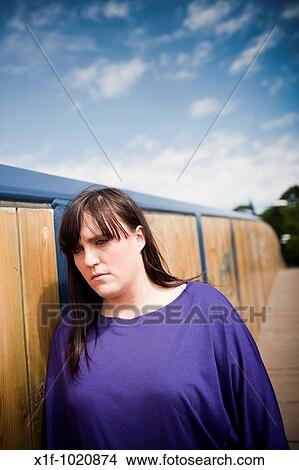 Sad depressed young overweight woman standing on walkway bridge View Large Photo Image Picture - Sad depressed young overweight woman standing on walkway bridge. Fotosearch