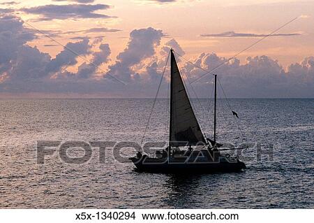 Picture - Sailboat at sunset off the coast of Negril, Jamaica. Fotosearch