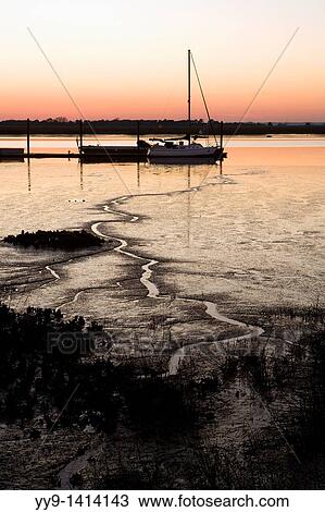 Stock Image - Sailboat in the sunset - Jekyll Island, Georgia USA. Fotosearch