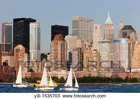 Stock Image - Sailboats on the Hudson River, with the lower Manhattan financial district of New York City as a backdrop, as seen from Liberty State Park, New Jersey, USA. Fotosearch
