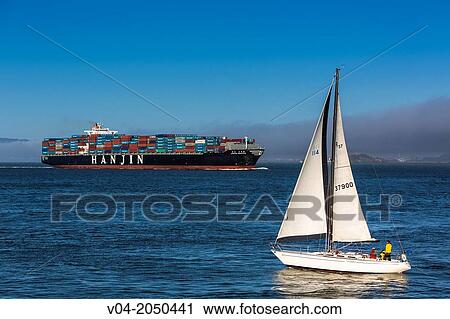 Stock Image - Sailing boat and large container ship in the San Francisco Bay, California, USA. Fotosearch