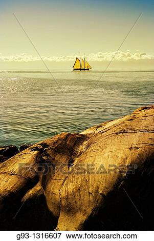 Stock Photo - sailing ship with rocks foreground. Fotosearch