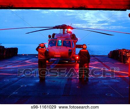 Stock Photo - Sailors assigned to Helicopter Combat Support Squadron Six HC-6, signal to start the engines of an MH-60S Seahawk helicopter prior to a vertical replenishment with the Nimitz-class aircraft carrier USS Harry S Truman. Fotosearch