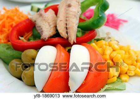 Stock Image - Salad on plate with olives, tomatoes, and eggs. Fotosearch