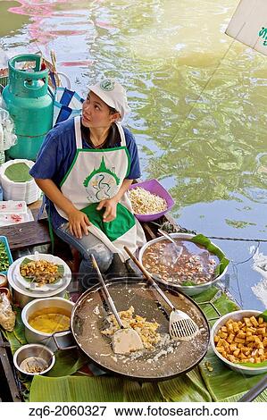 Stock Photo - Sale of Food on a Boat on the floating Market of Taling Chan in Bangkok, Thailand.. Fotosearch