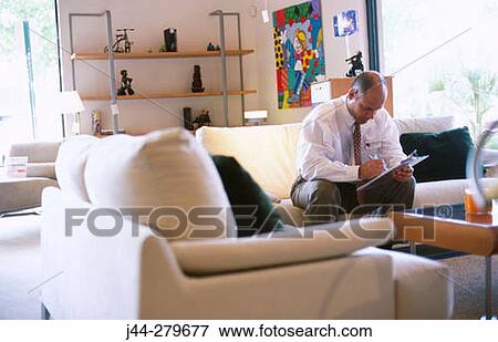 Salesman on a sofa taking notes in a furniture store View Large Photo Image Stock Photo - Salesman on a sofa taking notes in a furniture store. Fotosearch