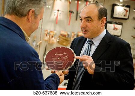 Stock Photo - Salesman with diamond blade, construction machinery. Fotosearch