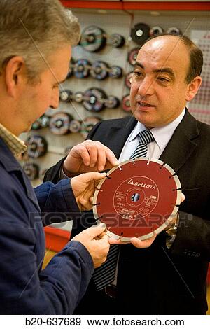 Stock Photo - Salesman with diamond blade, construction machinery. Fotosearch
