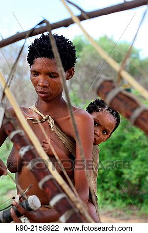 San woman busy with handicrafts and carrying her baby on her back, Namibia, Africa. View Large Photo Image Stock Image - San woman busy with handicrafts and carrying her baby on her back, Namibia, Africa.. Fotosearch