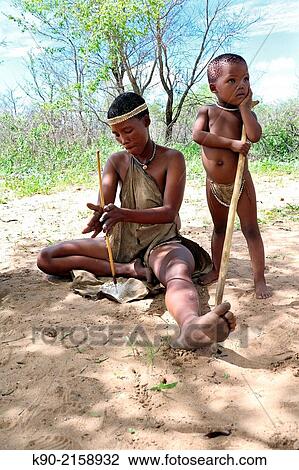 San woman drilling holes in small pieces of Ostrich eggs to form a necklace, Kalahari desert, Namibia, Africa. View Large Photo Image Stock Image - San woman drilling holes in small pieces of Ostrich eggs to form a necklace, Kalahari desert, Namibia, Africa.. Fotosearch