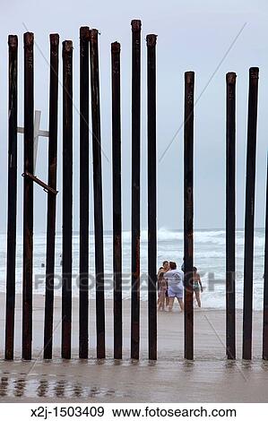 Stock Photo - San Ysidro, California - A fence at California's Border Field State Park separates the United States and Mexico on a beach at the Pacific Ocean. Fotosearch