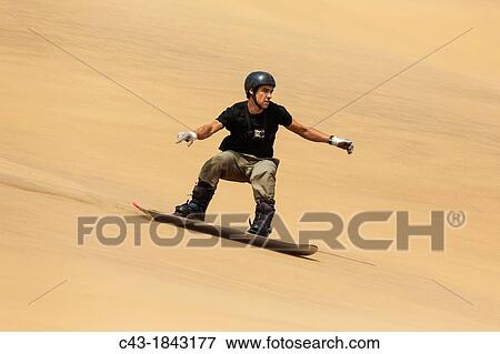 Sand boarding in the dunes of the Namib Desert near the coastal town of Swakopmund has become very popular Swakopmund, Namibia View Large Photo Image Stock Photo - Sand boarding in the dunes of the Namib Desert near the coastal town of Swakopmund has become very popular Swakopmund, Namibia. Fotosearch