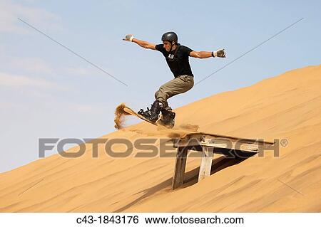 Sand boarding in the dunes of the Namib Desert near the coastal town of Swakopmund has become very popular Swakopmund, Namibia View Large Photo Image Stock Photograph - Sand boarding in the dunes of the Namib Desert near the coastal town of Swakopmund has become very popular Swakopmund, Namibia. Fotosearch