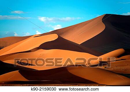 Sand dunes in the sun with shadows in the early evening, Sossusvlei, Namib-Naukluft Park, Namibia, Africa. View Large Photo Image Stock Image - Sand dunes in the sun with shadows in the early evening, Sossusvlei, Namib-Naukluft Park, Namibia, Africa.. Fotosearch