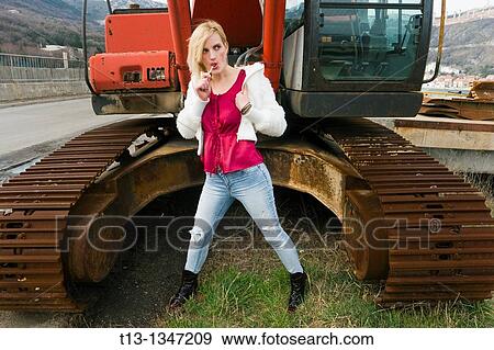 Sandwiched between bulldozer rusty tracks young woman is licking a lollipop View Large Photo Image Stock Photo - Sandwiched between bulldozer rusty tracks young woman is licking a lollipop. Fotosearch