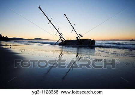 Santa Barbara, California: Sailboat washed ashore on beach during winter storm View Large Photo Image Stock Photograph - Santa Barbara, California: Sailboat washed ashore on beach during winter storm. Fotosearch