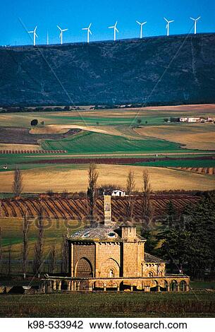 Stock Image - Santa Maria de Eunate (Romanico s. XII) y parque eolico del perdon al fondo. Muruzabal. Navarra. Spain.. Fotosearch