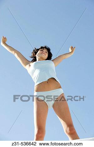 Stock Image - Santhi, Underwear, Stretching, Raising arms, Smiling, View from below. Fotosearch
