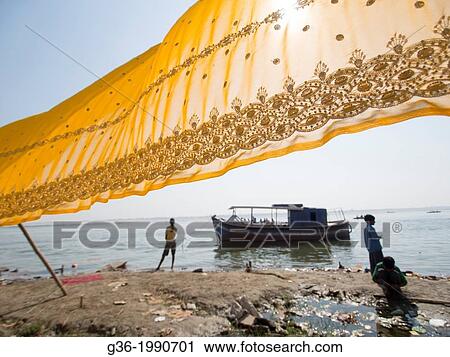 Stock Image - Sari being dried in front of a river in Varanasi, Uttar Pradesh, India.. Fotosearch