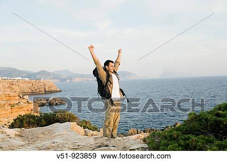 Satisfied man reaching the top View Large Photo Image Stock Photo - Satisfied man reaching the top. Fotosearch