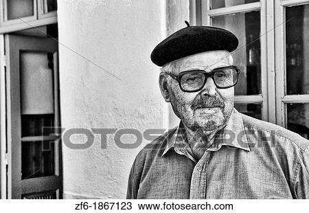 Scenes in local town of man with Greek hat in blue of Naoussa in quiet island of Paros in the Greek Islands of Greece Europe View Large Photo Image Stock Image - Scenes in local town of man with Greek hat in blue of Naoussa in quiet island of Paros in the Greek Islands of Greece Europe. Fotosearch