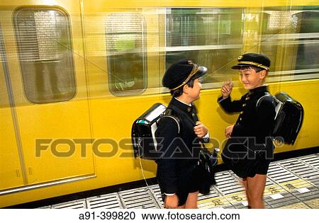 Stock Image - Schoolboys in black uniform in subway. Tokyo, Japan. Fotosearch