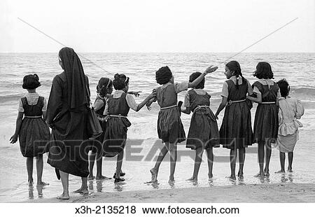 Stock Photo - schoolgirls and nun on the edge of the Arabian Sea, State of Kerala, India, South Asia.. Fotosearch