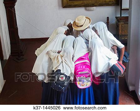 Stock Photograph - Schoolgirls looking at photos on phone in Palace Museum, Stone Town, Zanzibar. Fotosearch
