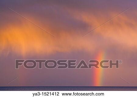 Stock Image - Scotland, Scottish Borders, Burnmouth Rainbow above the north sea, photographed just before sunset. Fotosearch