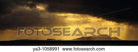 Stock Image - Scotland, Western Isles, Isle of Soay Dramatic shafts of light from the settin sun above the Isle of Soay, viewed from Elgol on the Isle of Skye. Fotosearch