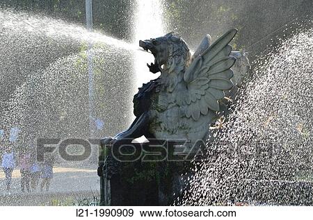 Sculpture of a winged dragon backlit, which sprays water through the mouth. It is part of a group of sculptures of winged dragons guarding the waterfall of Ciutadella Park. Parc de la Ciutadella, Barcelona, Catalonia, Spain. View Large Photo Image Stock Photo - Sculpture of a winged dragon backlit, which sprays water through the mouth. It is part of a group of sculptures of winged dragons guarding the waterfall of Ciutadella Park. Parc de la Ciutadella, Barcelona, Catalonia, Spain.. Fotosearch