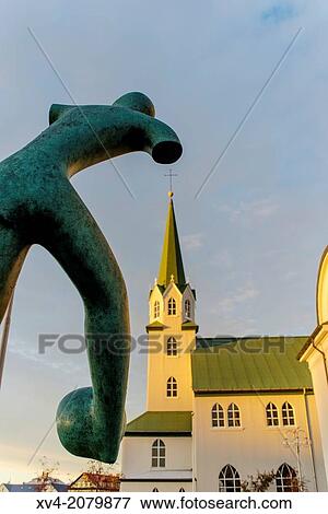 Stock Photo - Sculpture with Frikirkjan church background on Tjorn lake in Autumn, Reykjavik, Iceland.. Fotosearch