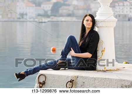 Seated on a quay young woman View Large Photo Image Stock Photograph - Seated on a quay young woman. Fotosearch